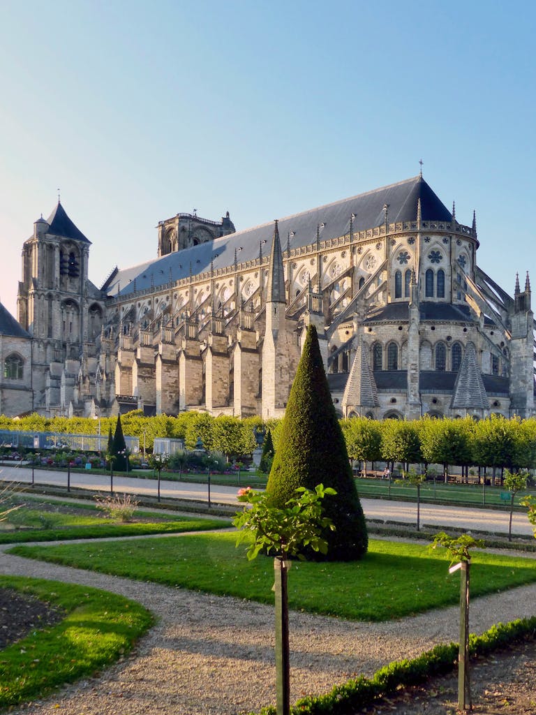 Stunning Gothic architecture of Bourges Cathedral surrounded by lush gardens in France.