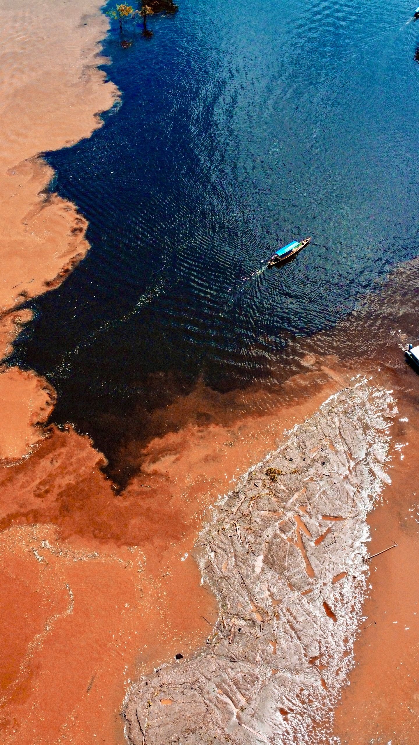 Aerial view capturing a lone boat navigating the river in the Amazonas region, Colombia.