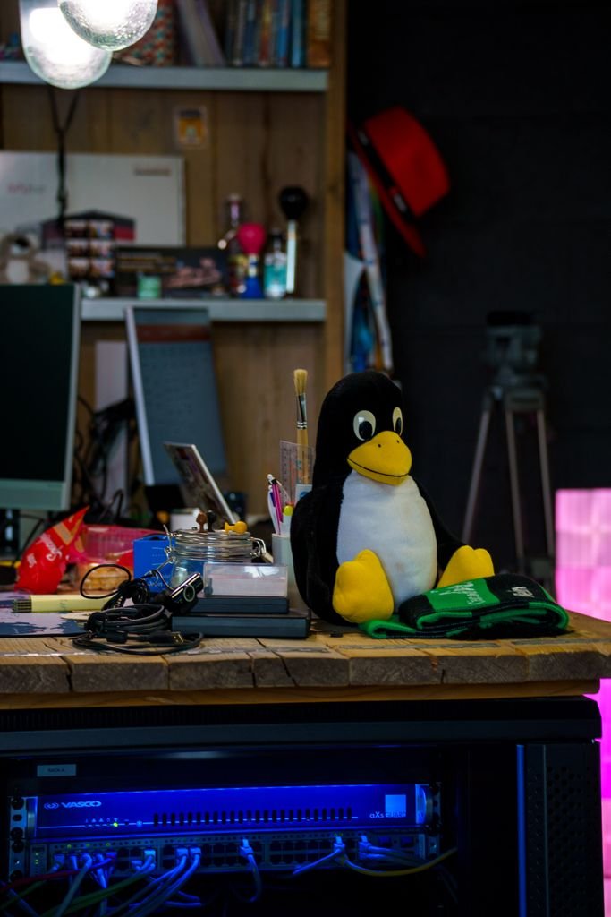 Colorful tech workspace featuring the Tux penguin mascot on a desk.